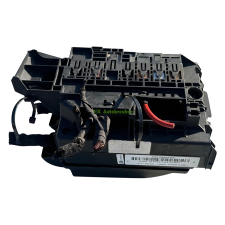 Automotive electrical module with multiple slots and tangled wires, including a red power lead.