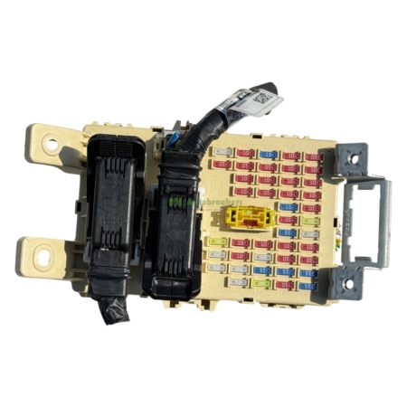 Car fuse/relay box with colorful fuses and a black wiring harness attached on one side, viewed from above.